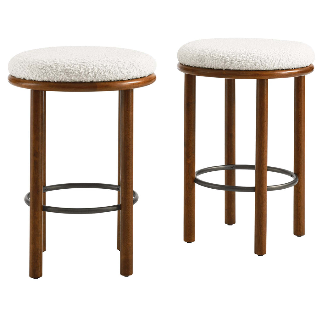 Counter stool with white cushion and wooden legs shown from the side.